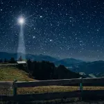 Gwiazda Betlejemska świecąca nad pastwiskiem i stajnią w górach. Wieczorna scena wigilijna.